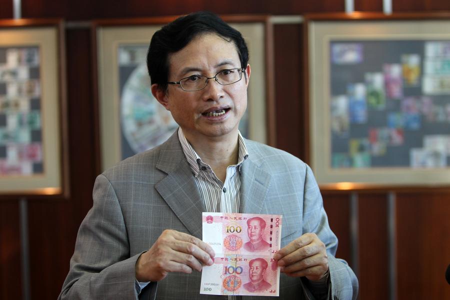43 armored cash-in-transit vans wait in line to transport new 100-yuan banknotes